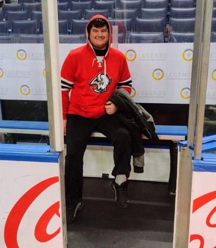 Dan Dale sitting on hockey rink bench